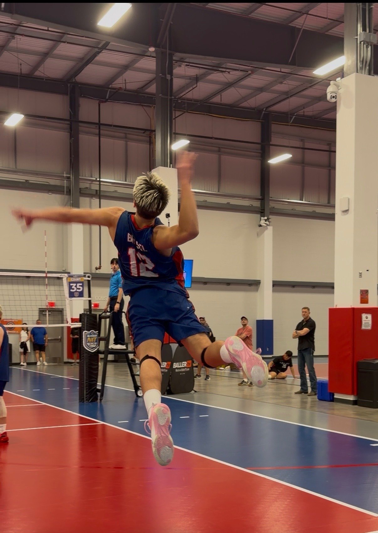 Asher Brasel #12 rising above the net to serve
